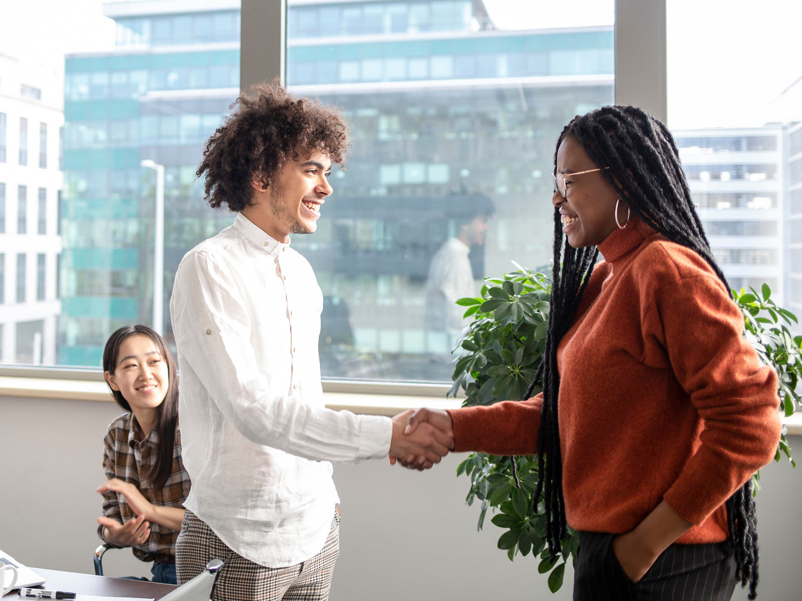 two people, part of a group, shaking hands